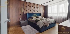 Кровать из массива дерева с синей тканевой обивкой